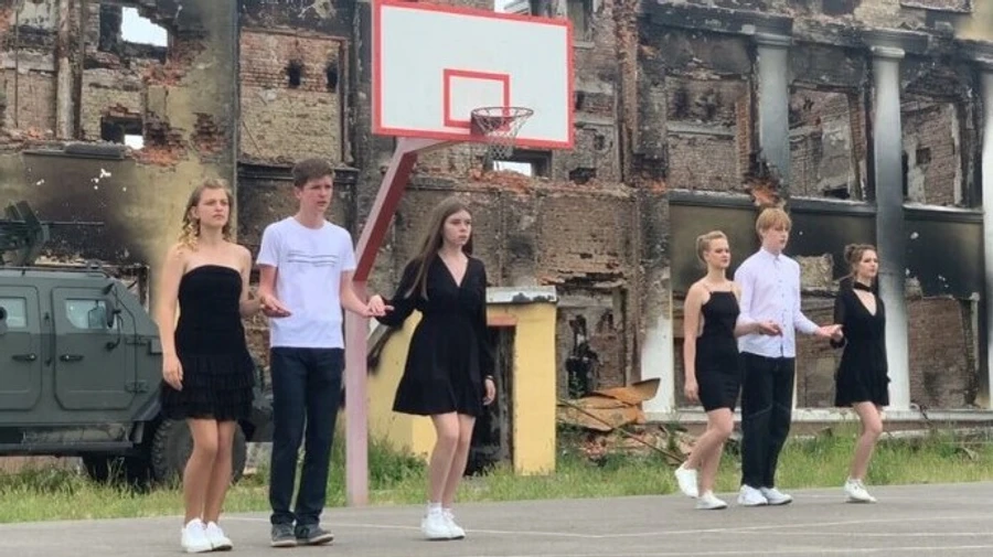 Sombre waltz of Kharkiv high school graduates in front of their school's ruins