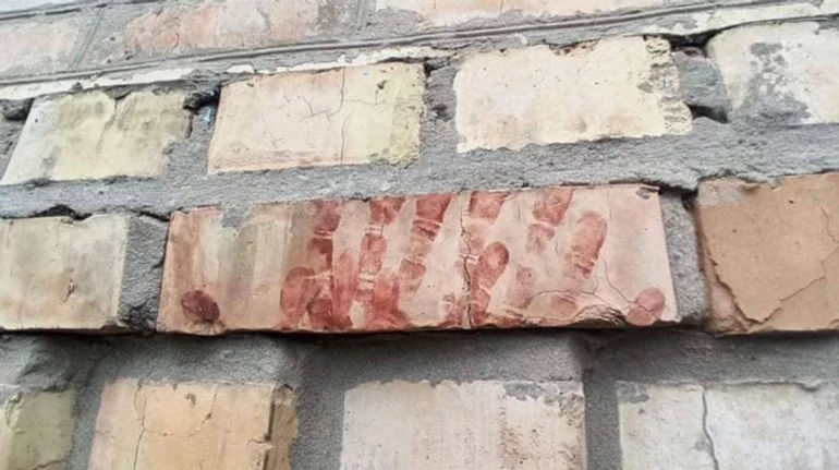 На одній зі стін – досі кривавий відбиток долоні. Трагедія родичів та сусідів, яких закатували в Бучі