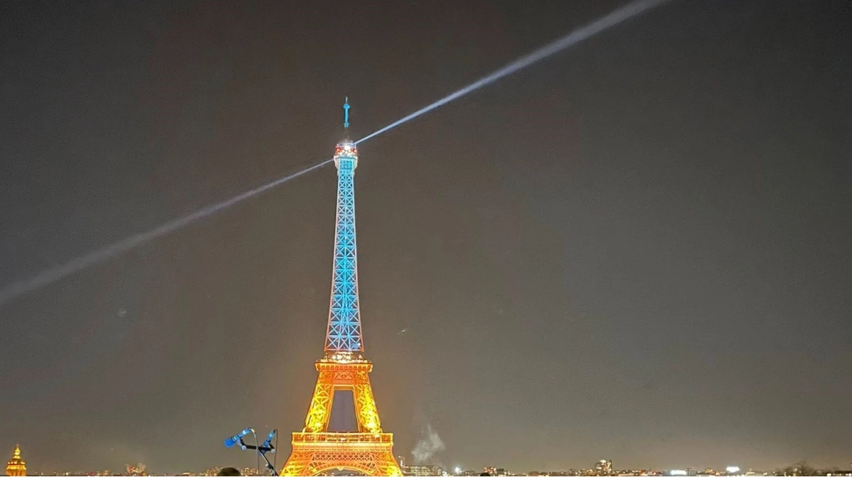 Eiffel Tower lit up in blue and yellow in Paris as sign of solidarity