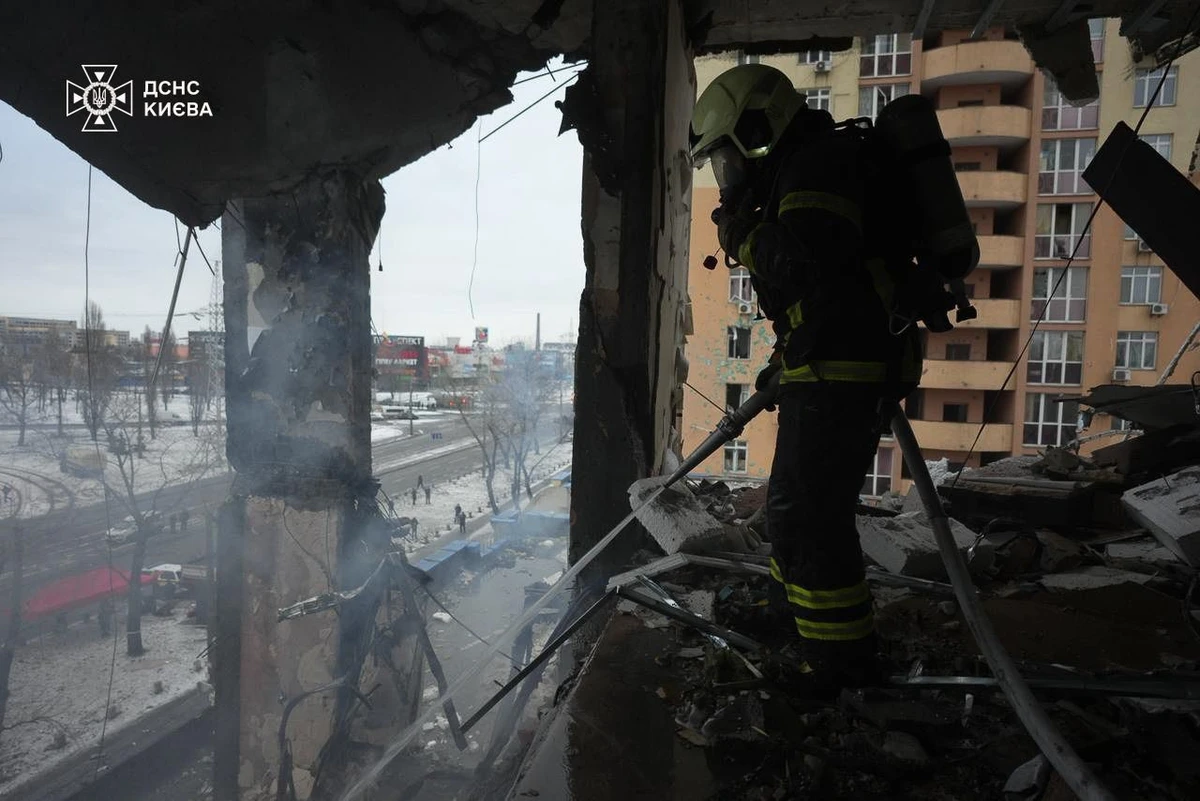 A firefighter works amid shattered concrete inside a heavily damaged building.