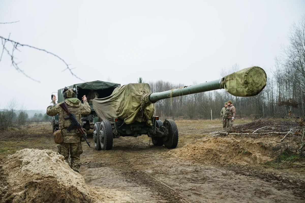 An artilleryman directs the delivery of the gun to the position.