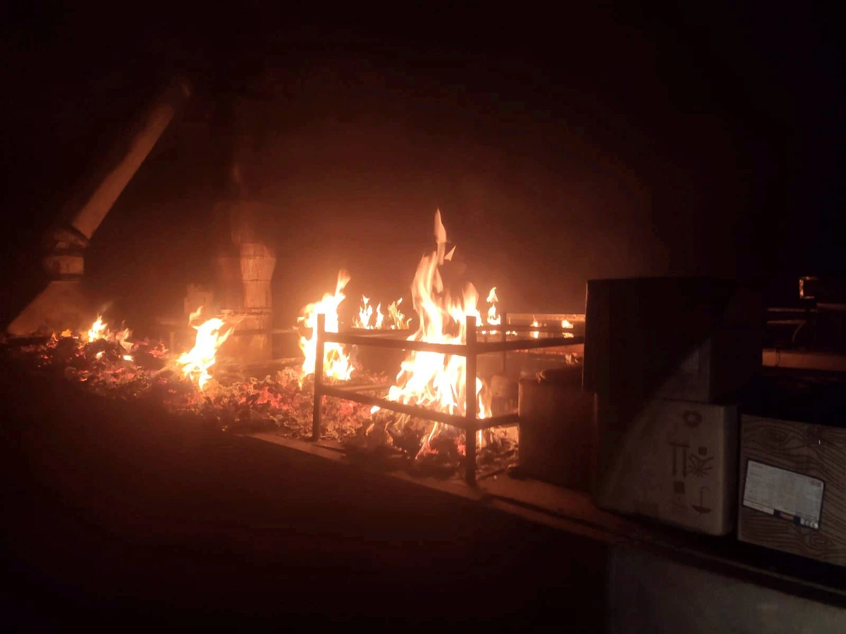 Flames burn across a darkened rooftop area