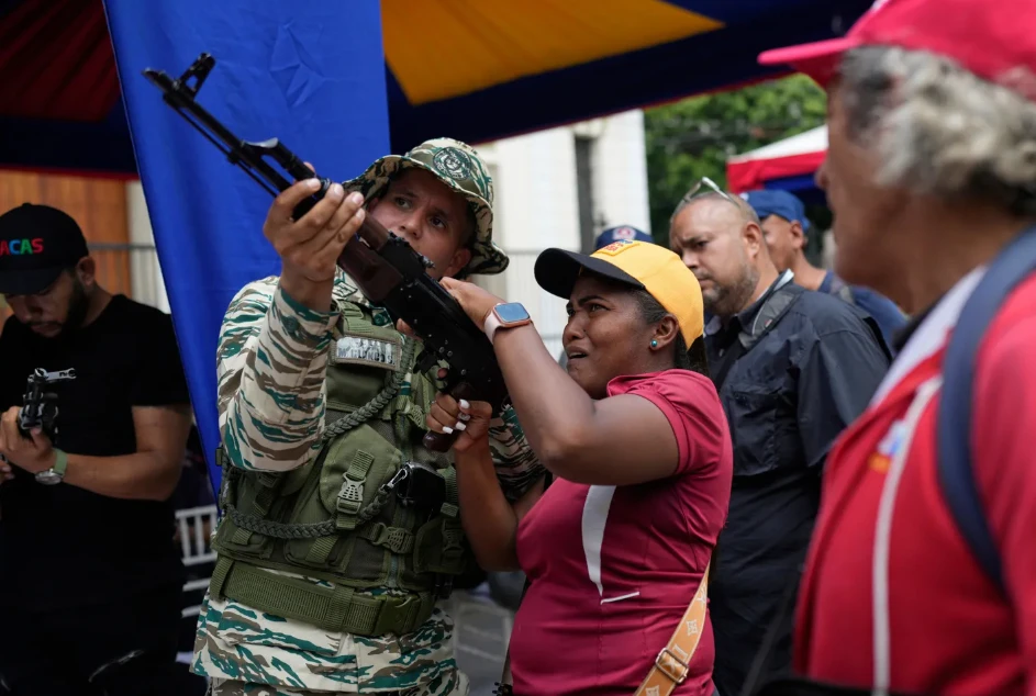 A member of the Bolivarian National Militia shows a woman how to use a weapon during military training in Caracas.