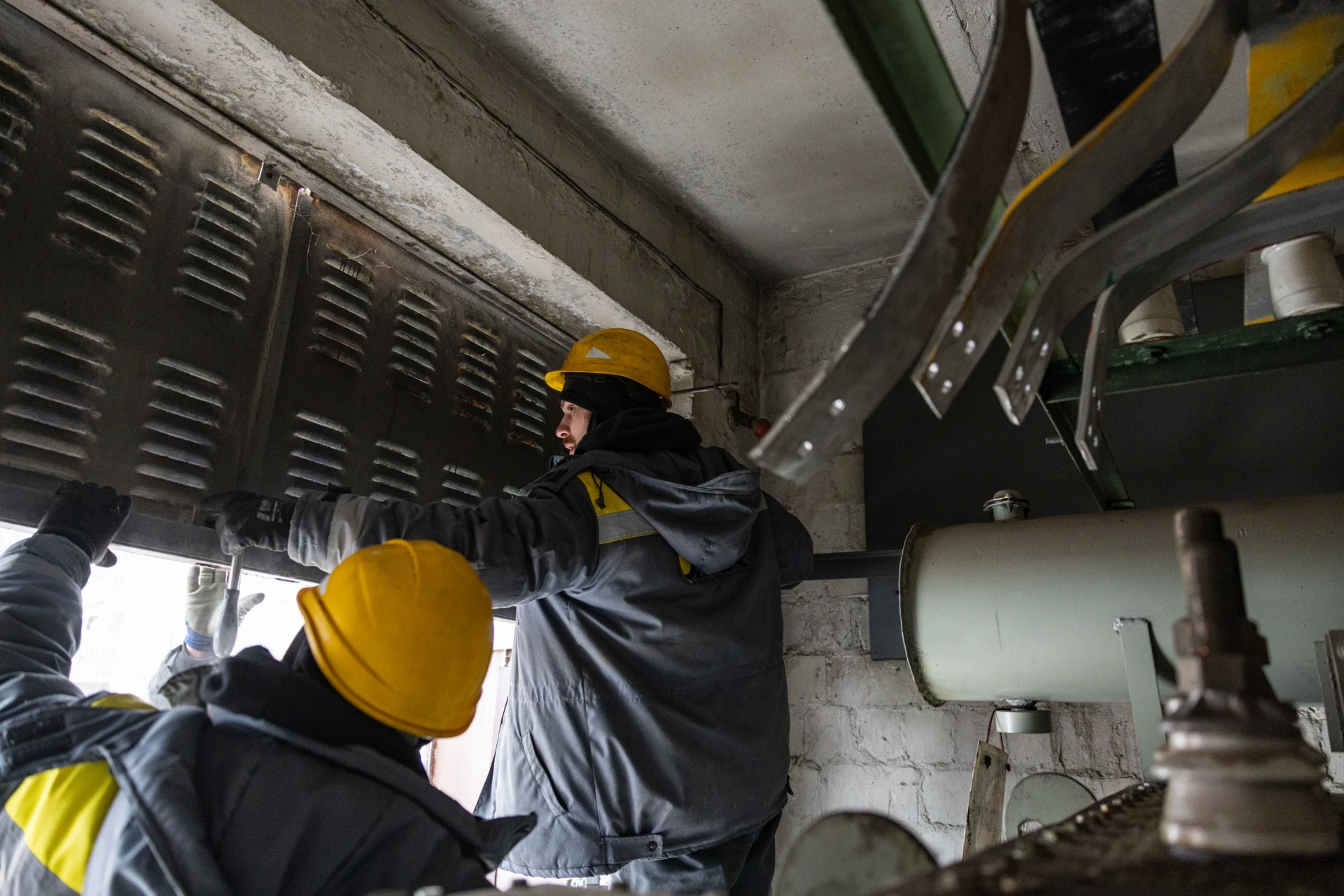 Ремонтна бригада енергетиків розбирає двері трансформаторної підстанції, щоби замінити згоріле обладнання