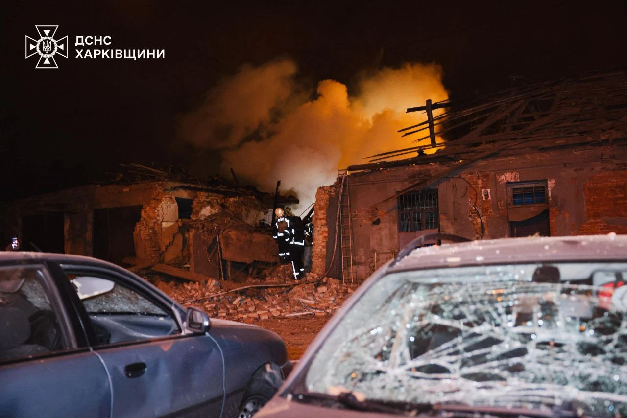 Damaged cars and a building on fire