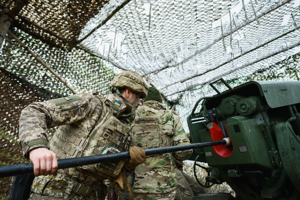 Loading the gun with a shell and propellant charge.