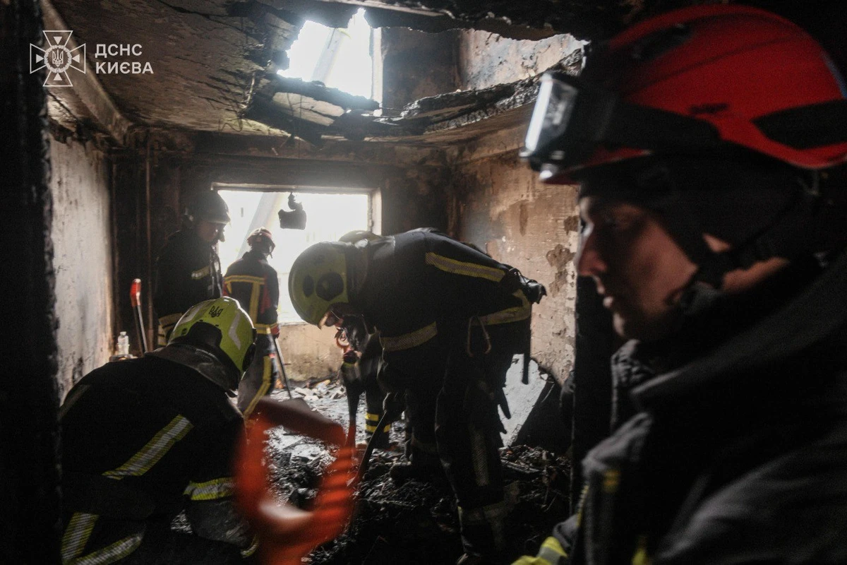 Firefighters work inside a heavily damaged, smoke-blackened building destroyed by a Russian strike in Kyiv.