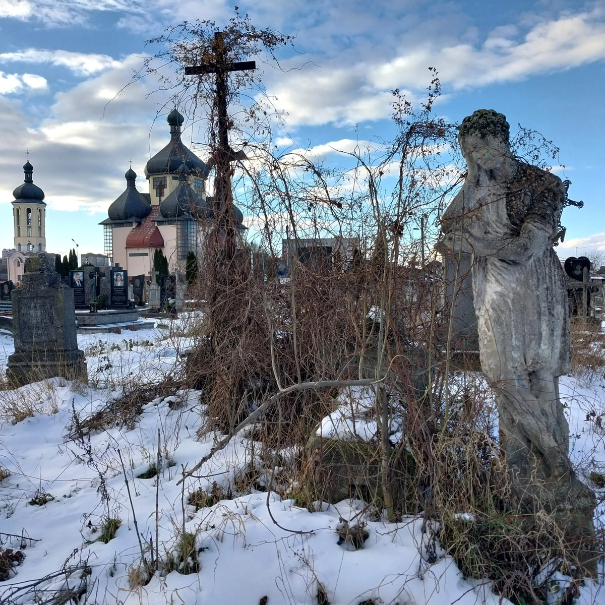 Давнє бурштинське кладовище. На задньому плані – греко-католицька церква священномученика Йосафата. Побудована у 2001 році