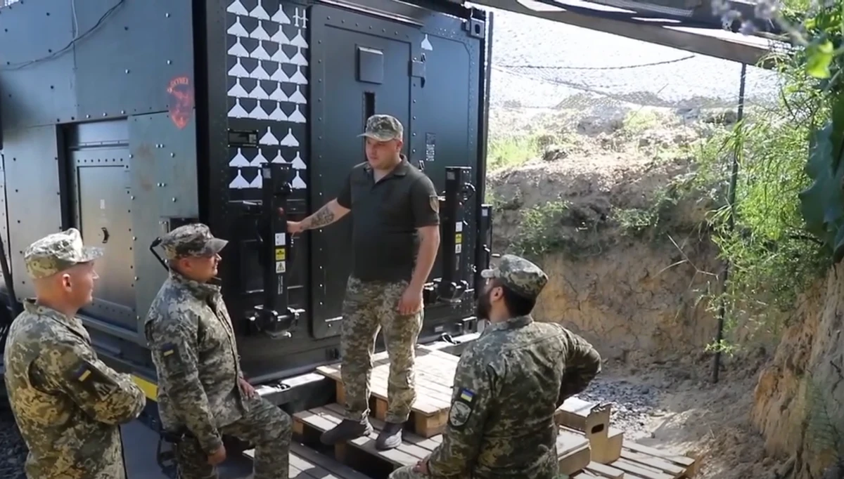 Ukrainian soldiers stand next to a Skynex system. Behind them, markings indicate the targets the unit has shot down