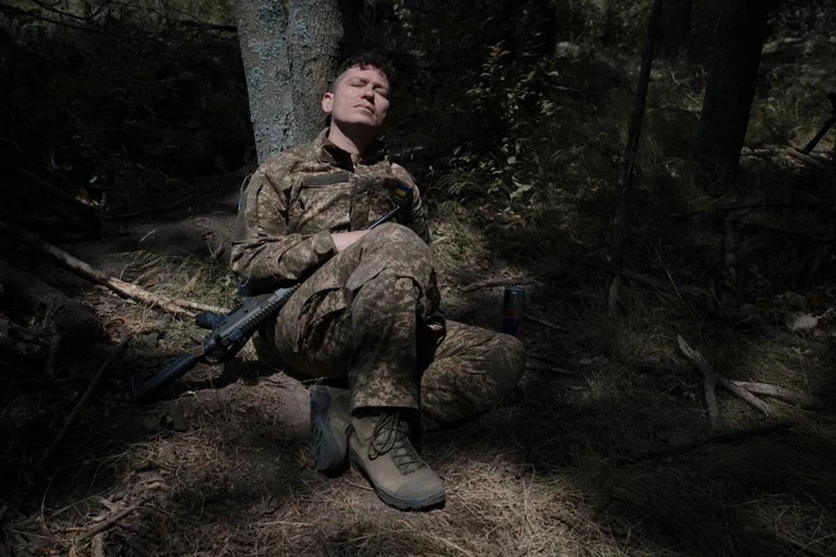A soldier sleeping under a tree.