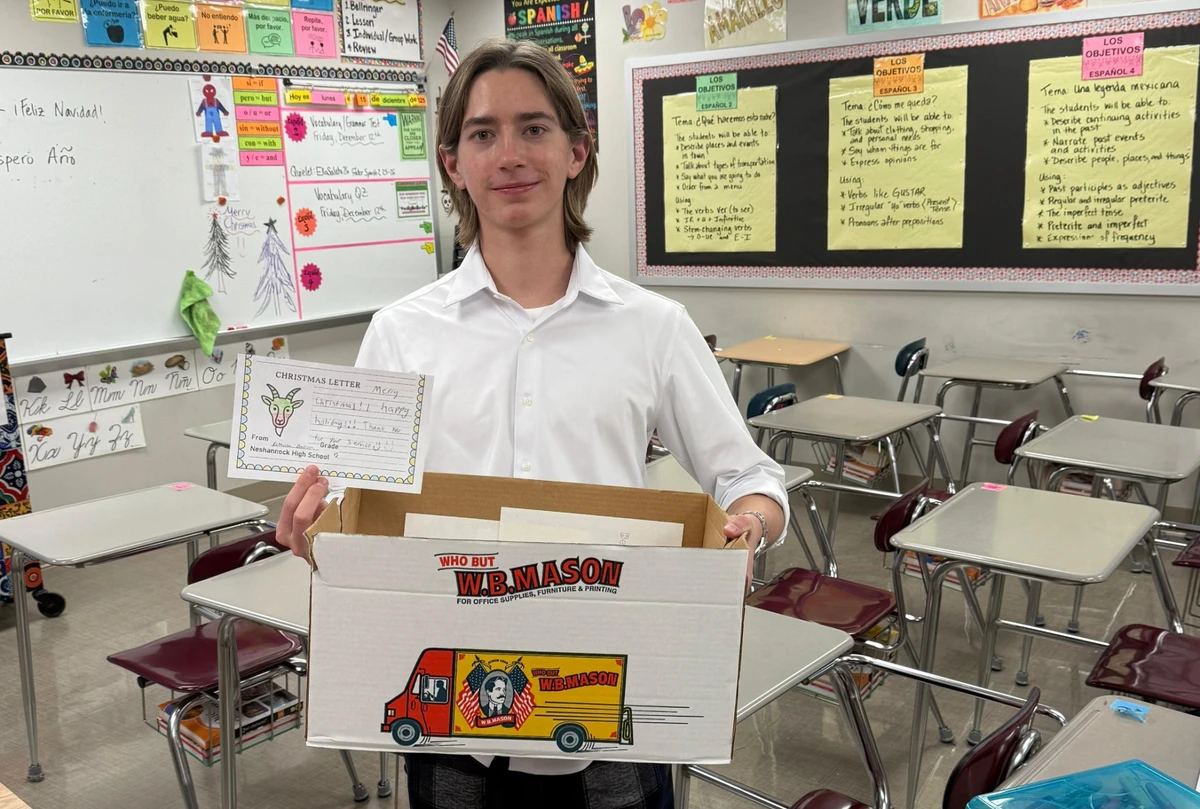 Arsenii at his school with a box of letters for the Ukrainian military