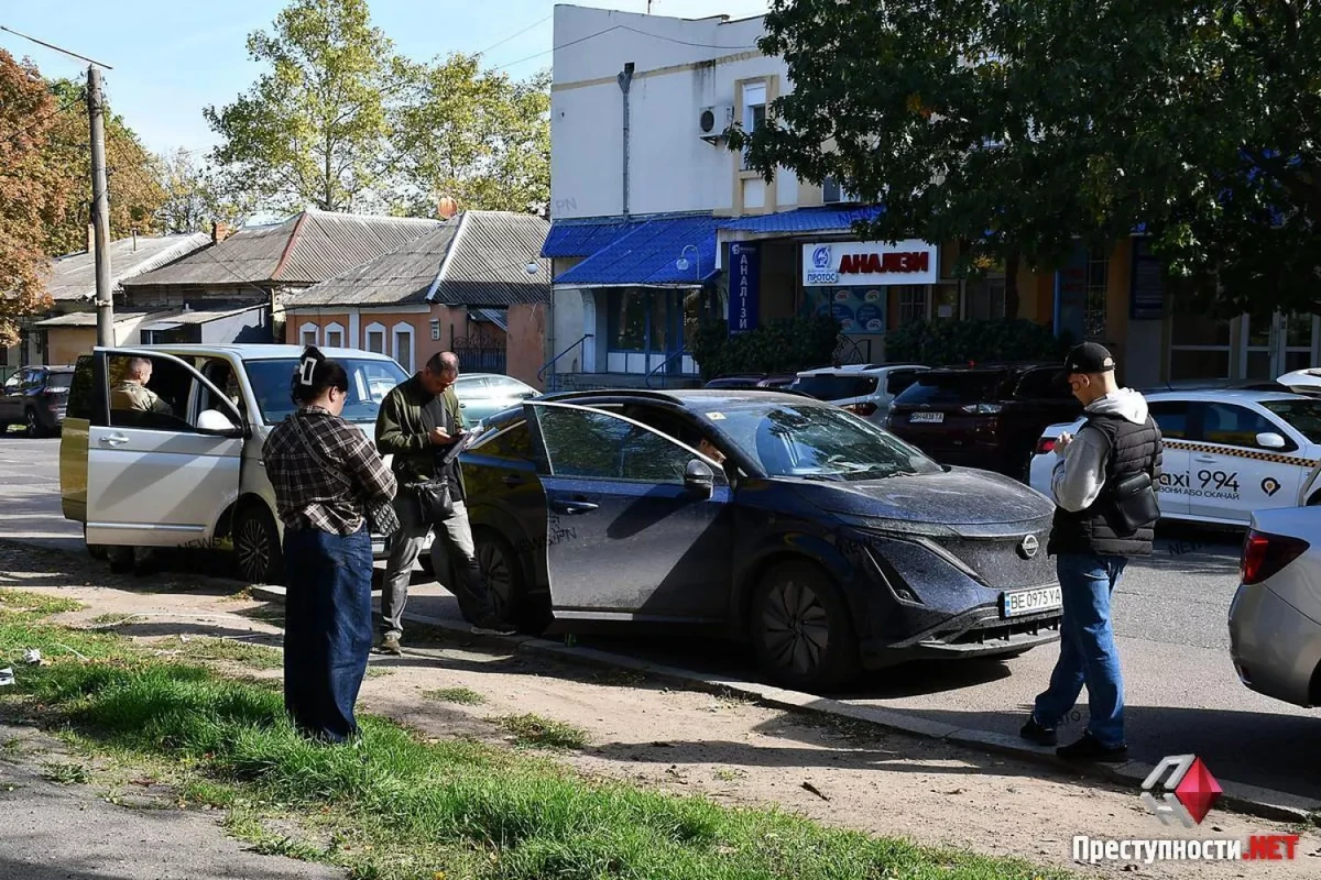 Співробітники з шевронами НАБУ біля автомобіля Nissan у центрі Миколаєва. Фото: ПН