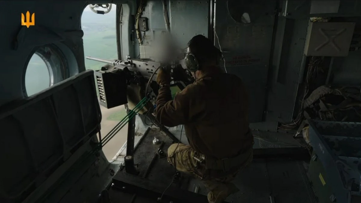 A still from a video released by the Ukrainian Ground Forces press service showing an onboard gunner operating an American M2 Browning machine gun aboard a Mi-8 helicopter during combat operations