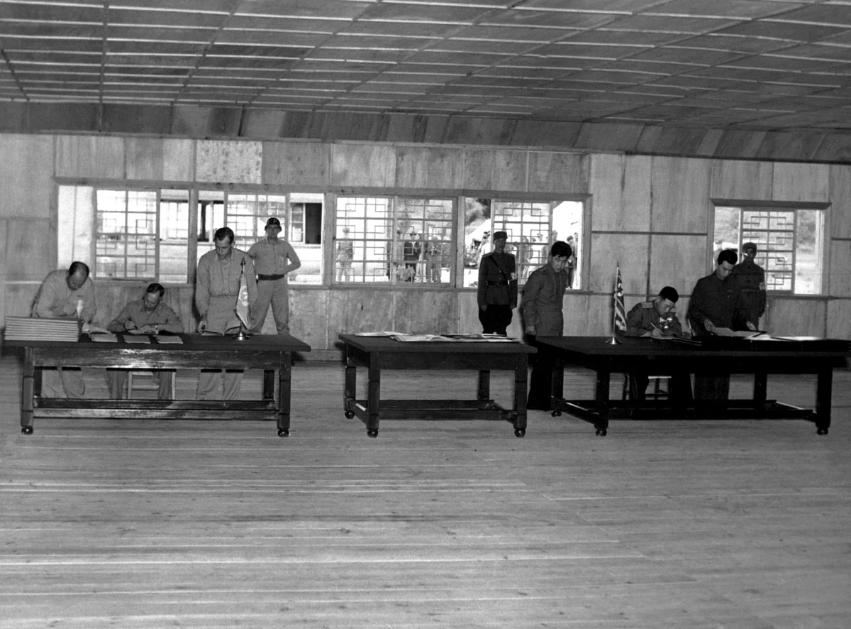 Генерал-лейтенант армії США Вільям Гаррісон-молодший (ліворуч) і північнокорейський генерал Нам Іл (праворуч) підписують перемир'я, що поклало край трирічному корейському конфлікту