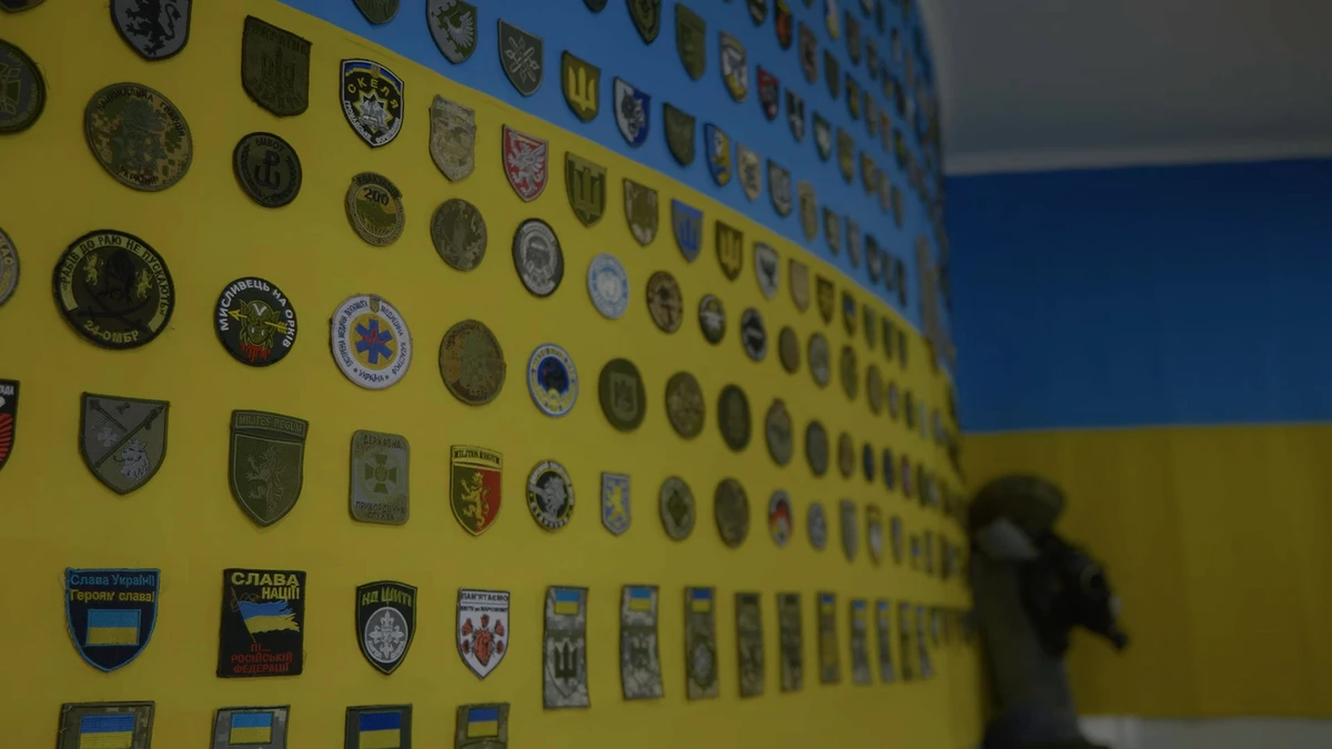 Флаг Украины, украшенный шевронами подразделений, в морге, где готовят к захоронению погибших воинов