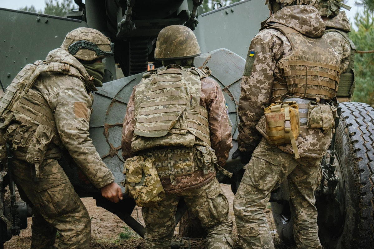 The crew installs the gun's base plate, which stabilises its weight during firing.