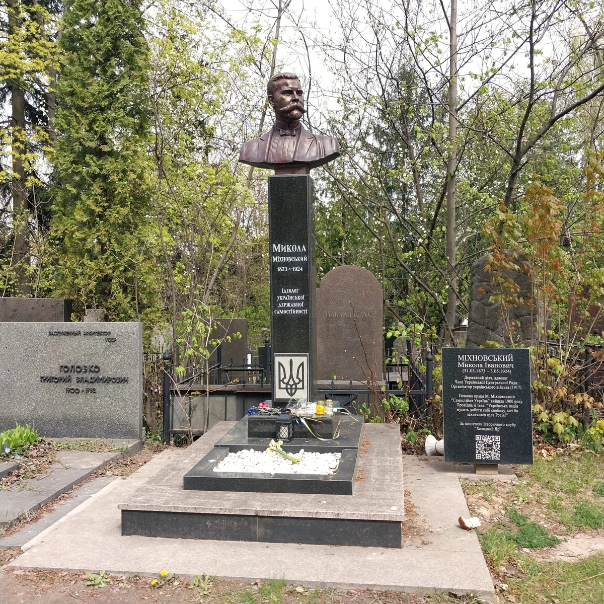 Памятник Михновскому недалеко от места, которое идентифицируют как могилу отцу украинского национализма. Это не первая версия постамента, который периодически атакуют вандалы. Во время работы на Байковом журналист УП увидел возле памятника припаркованный автомобиль муниципальной охраны. По словам охранников, КГГА специально отправляет сюда охрану