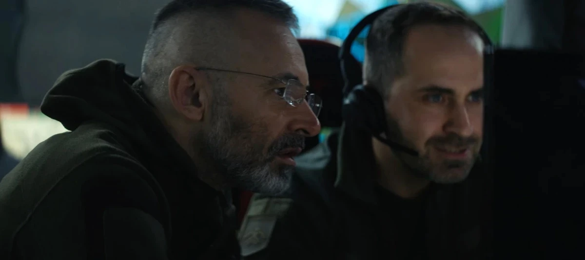 The video features unit commander Vsevolod Kozhemiaka (left) and Dmytro Dienkov (right), the former editor-in-chief of Ekonomichna Pravda, who now serves with Khartiia
