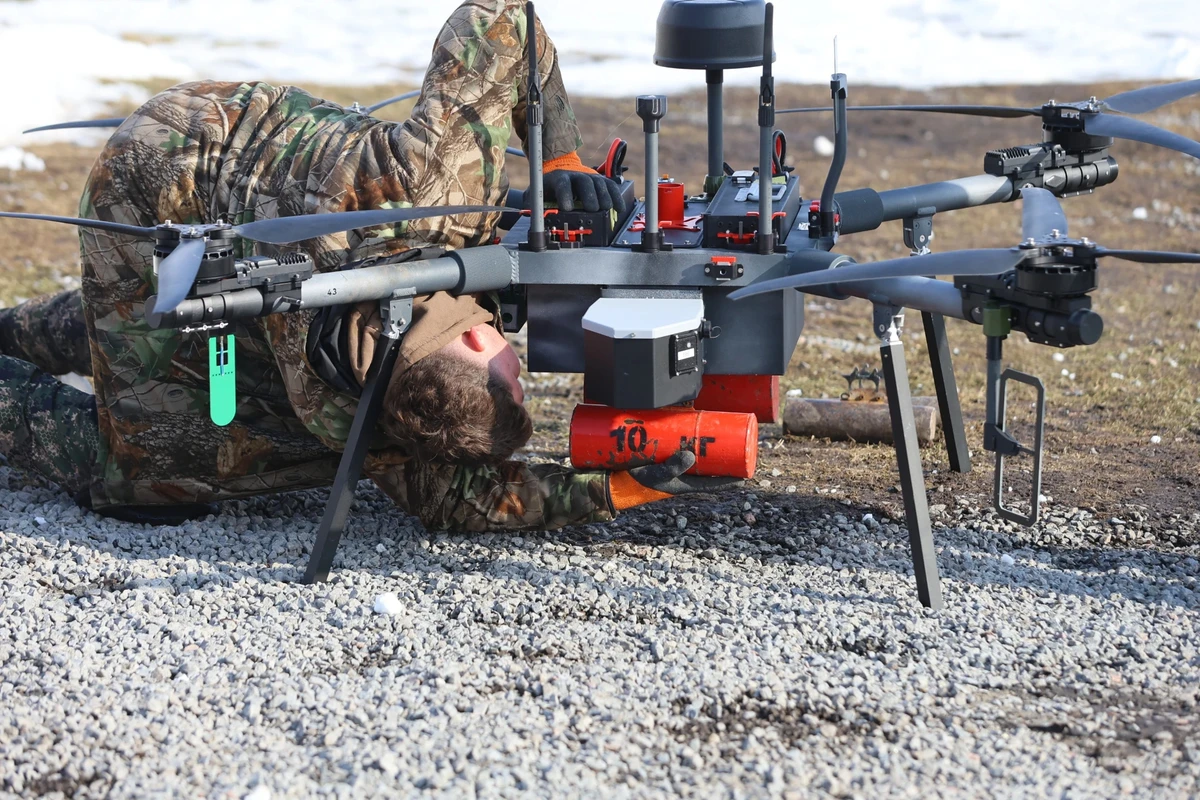A technician prepares a drone for take-off