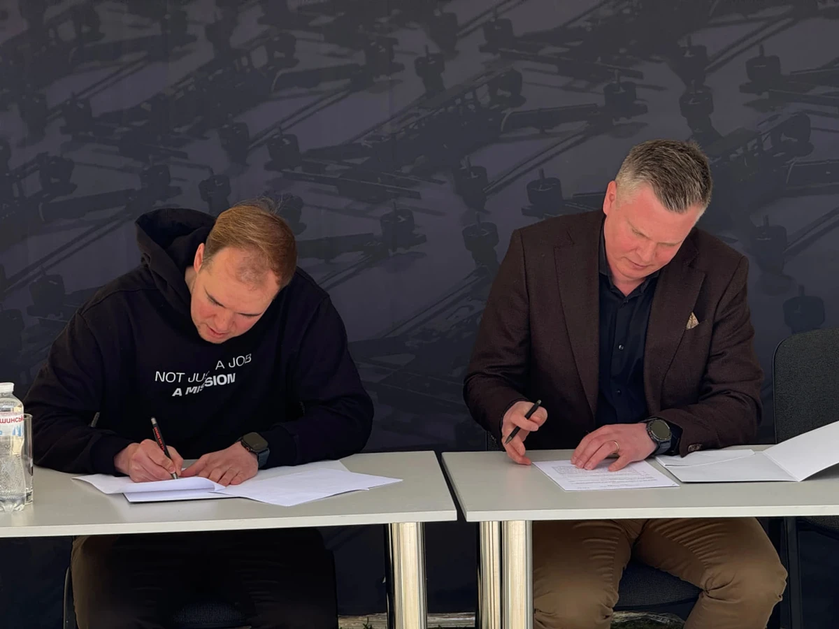 O CEO da TAF Industries, Volodymyr Zinovskyi, assina o acordo junto com o cofundador da Summa Defense, Jussi Holopainen