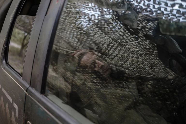 A soldier sleeping in a car.