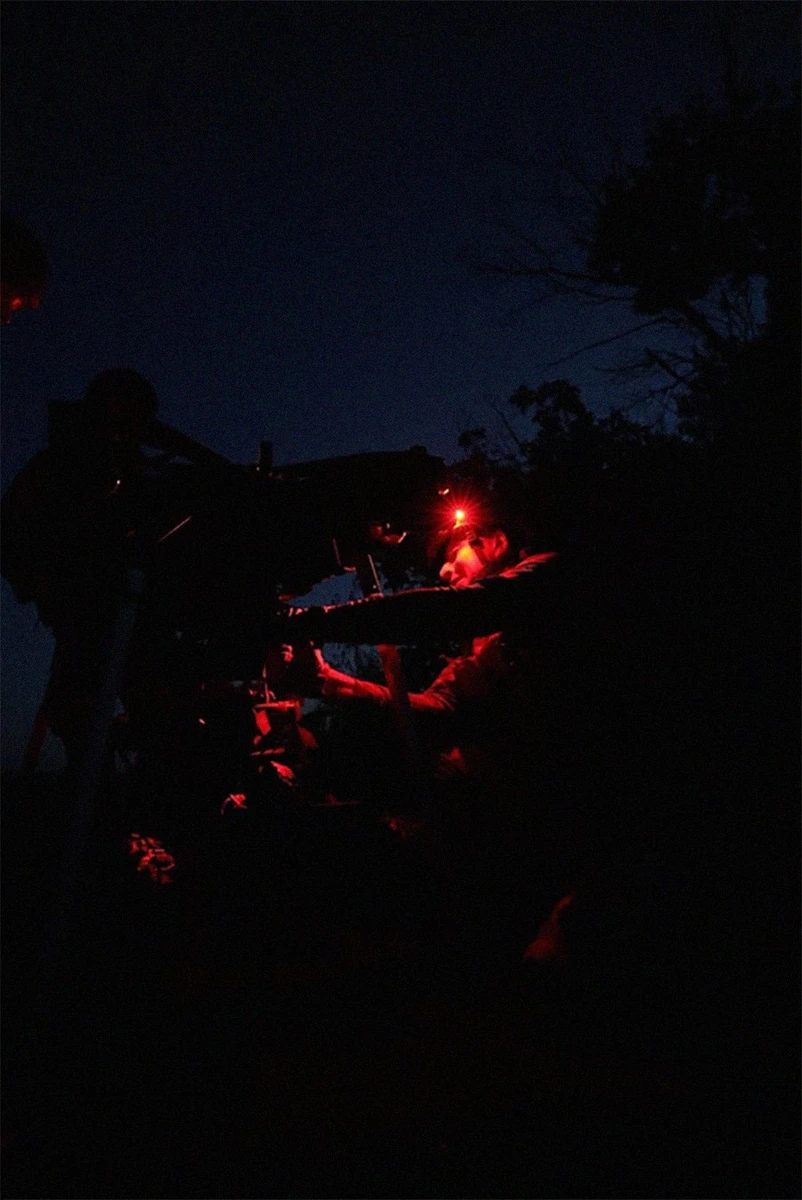A service member attaches an unmanned ground vehicle (UGV) to a heavy bomber drone