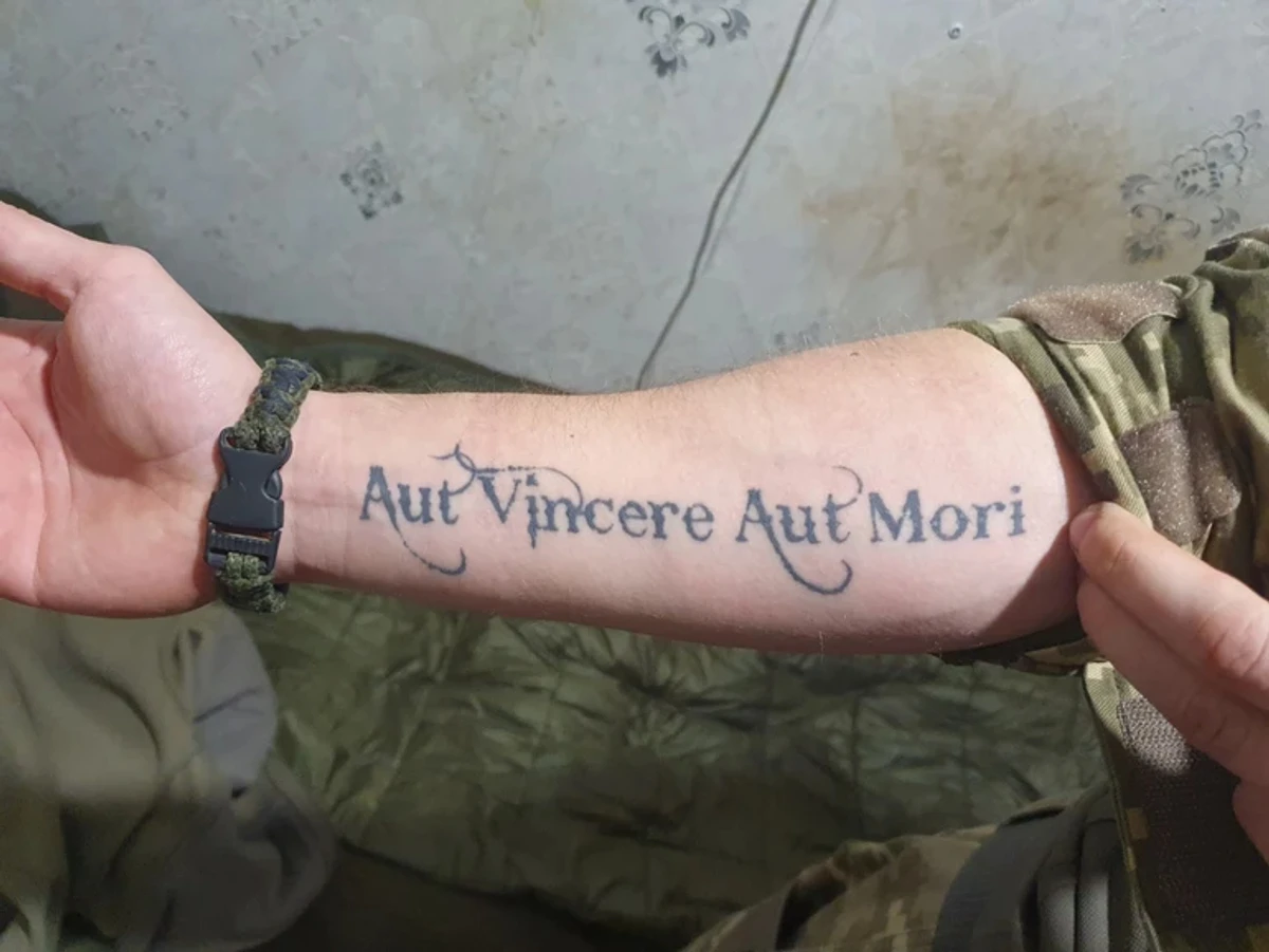 Roland suffered particularly harsh treatment during captivity because of his tattoo with the Latin phrase Aut vincere aut mori (Victory or death)