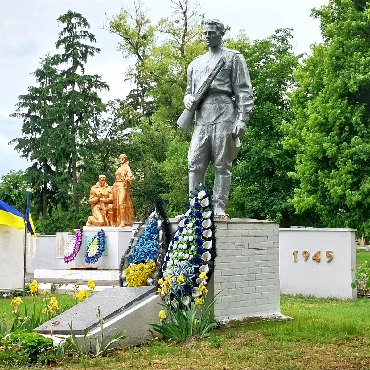 На новітній алеї пам'яті, яка з'явилася на радянському меморіалі, вже зо тридцять портретів із чорними стрічками та стільки ж синьо-жовтих прапорів