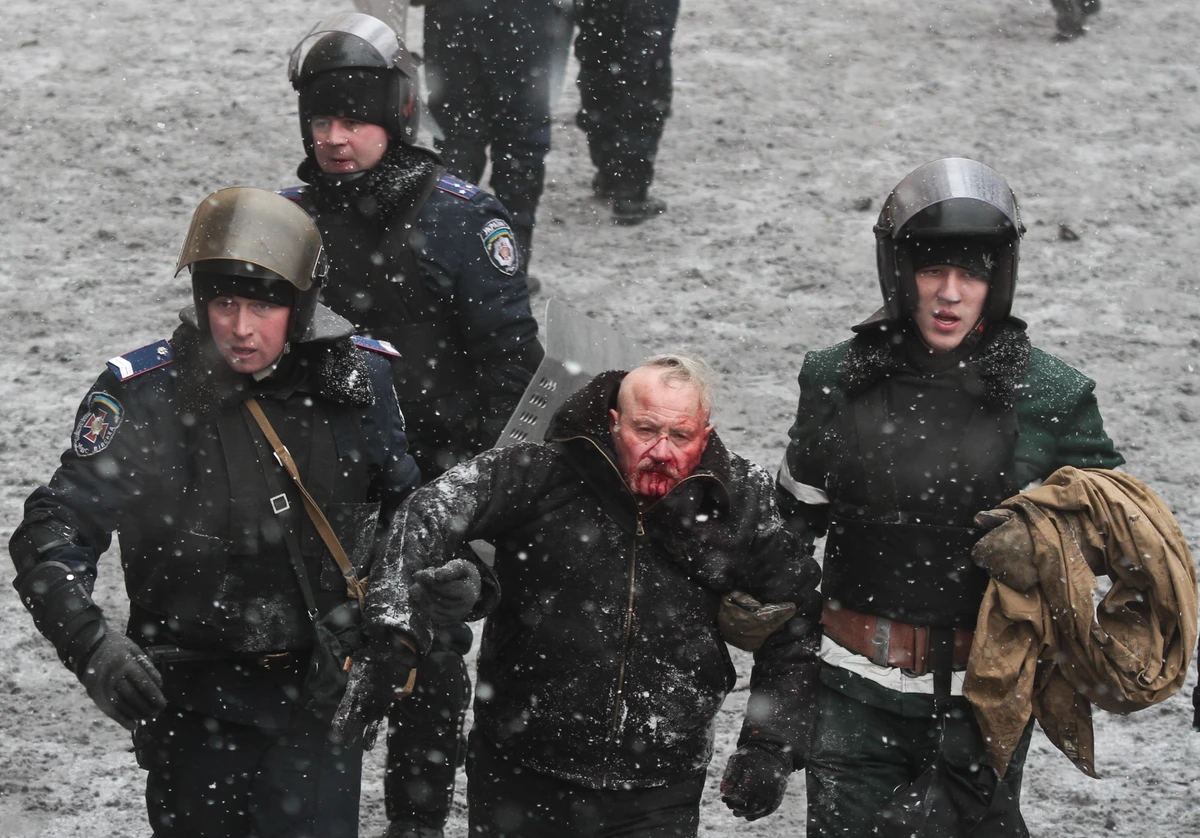 Спецназовцы Беркута ведут избитого майдановца Николая Пасечника на ул. Грушевского/22 января 2014 года