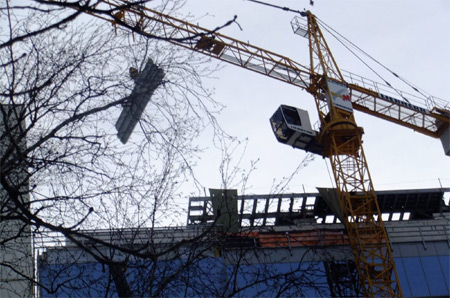 Кран з будівництва літає над будинками Кран з будівництва літає над будинками