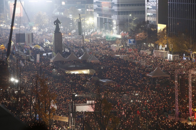 Используя свечи, а также экраны телефонов как фонарики, протестующие прошли маршем по улицам столицы