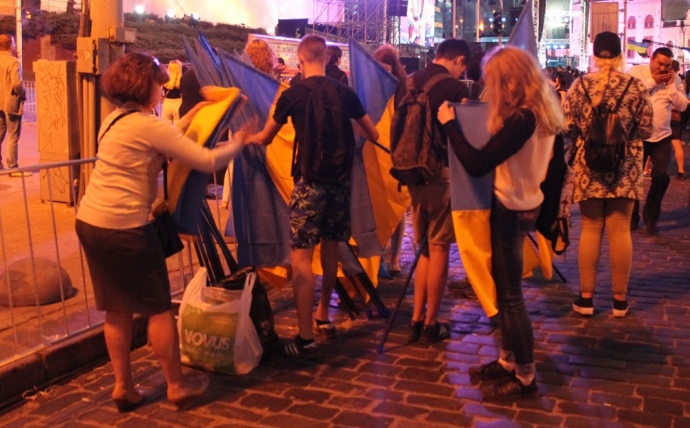 ФОТО13. У розпал концерту молоді люди організовано складали державні прапори у пакети