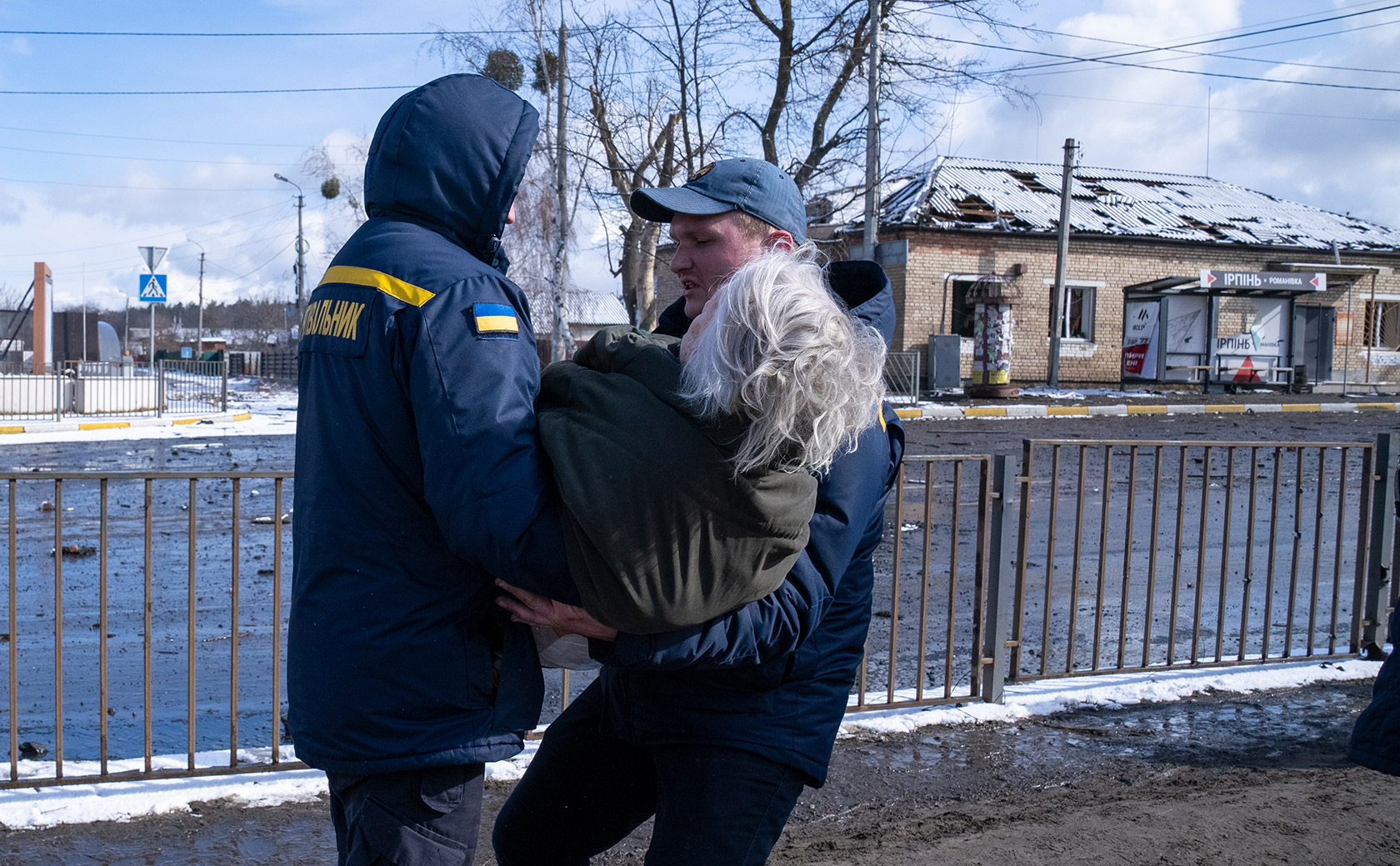 Працівники ДСНС допомогають літній жінці під час евакуації з міста Ірпінь