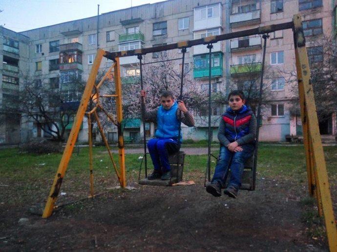 Руслан (праворуч) на відремонтованій гойдалці. Він з азартом переповідає, як ледь не став жертвою обстрілу