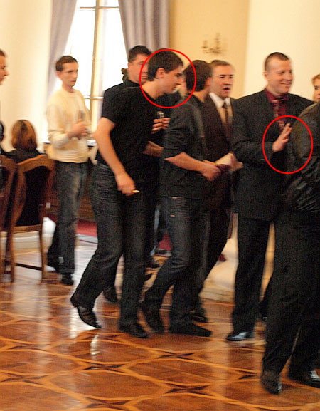 Охоронець (справа) і співробітник прес-служби мера (зліва) тримають Шкуріна. Журналіст стверджує, що йому допомогли йому не впасти